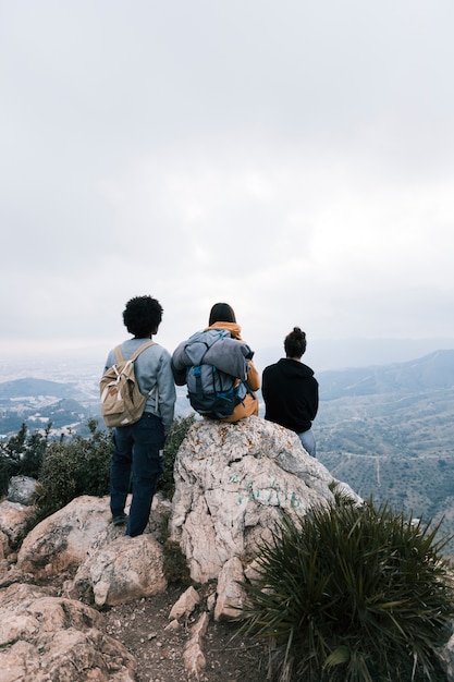 Tres amigos en la cima de la montaña mirando a la vista
