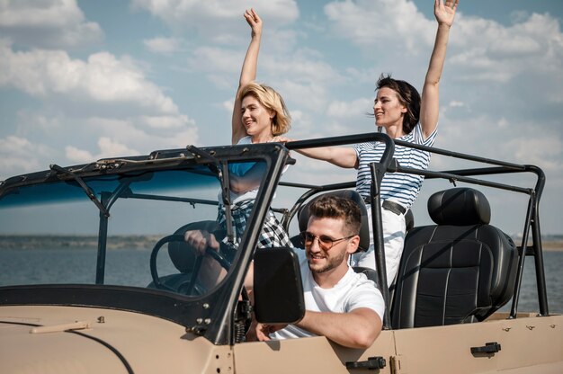 Tres amigos divirtiéndose viajando en coche.