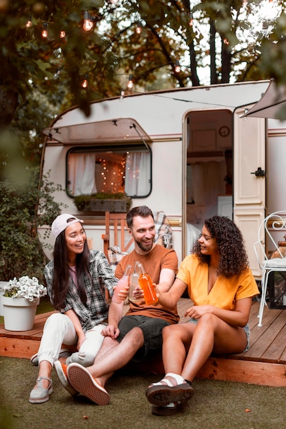 Foto gratuita tres amigos felices frente a autocaravana