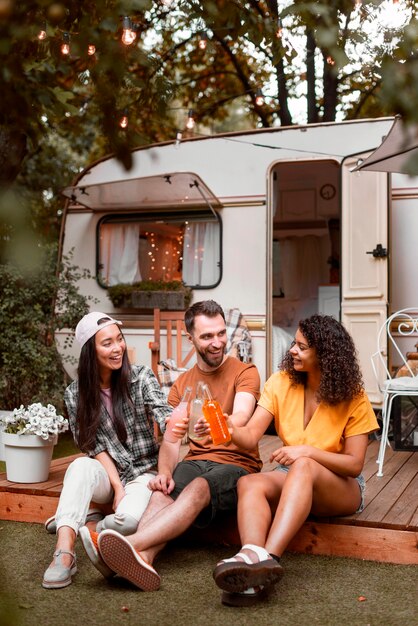 Tres amigos felices frente a autocaravana