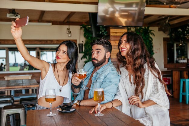 Tres amigos haciendo un selfie con cerveza
