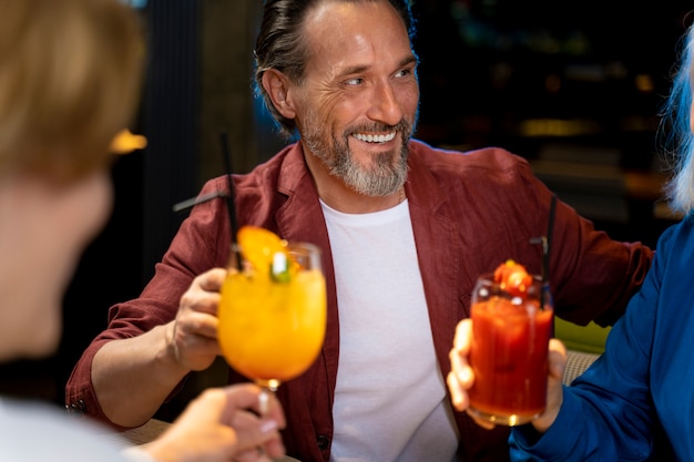 Tres amigos mayores bebiendo y hablando en un restaurante