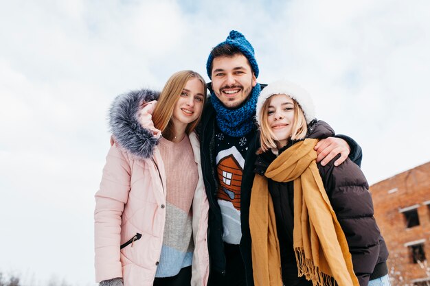 Tres amigos de pie en ropa de invierno afuera