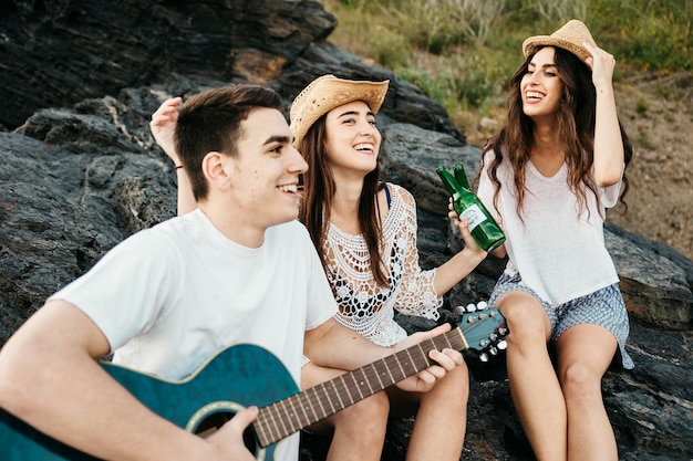 Tres amigos en la playa con guitara