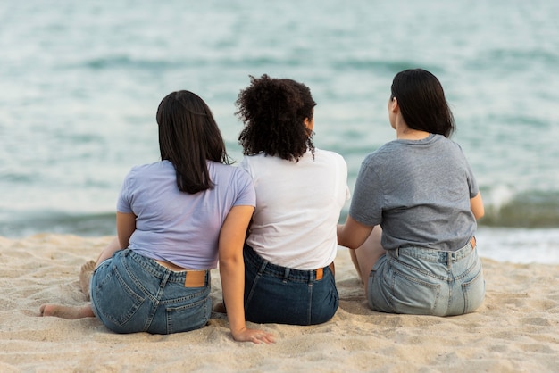 Tres amigos sentados en la playa