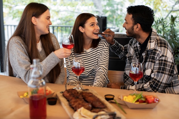 Foto gratuita tres amigos en una tertulia bebiendo vino