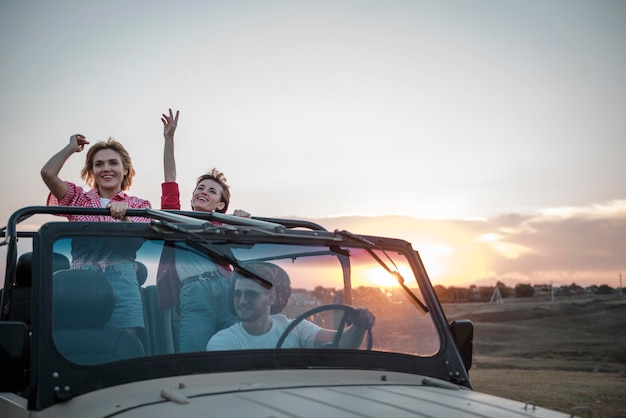 Tres amigos viajando en coche y divirtiéndose.