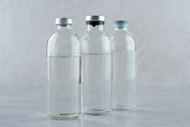 Tres botellas de etanol médico sobre fondo gris. Foto de alta calidad