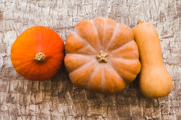 Foto gratuita tres calabazas maduras en la mesa