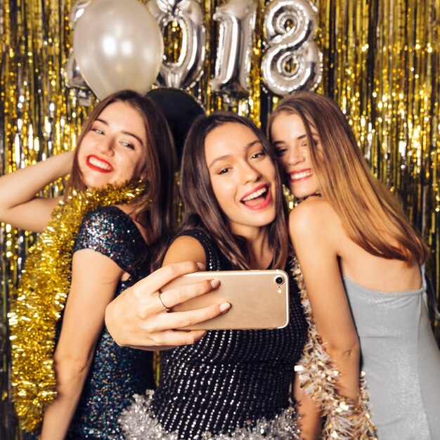 Tres chicas de fiesta haciendo un selfie en celebración de año nuevo