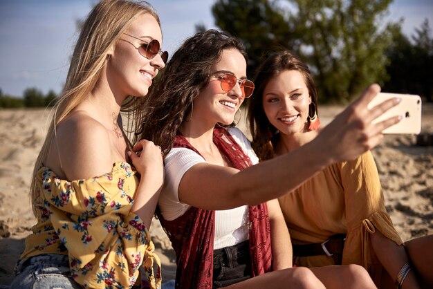 Tres chicas tomando un selfie en la playa.