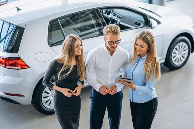 Tres colegas que trabajan en una sala de exposición de automóviles