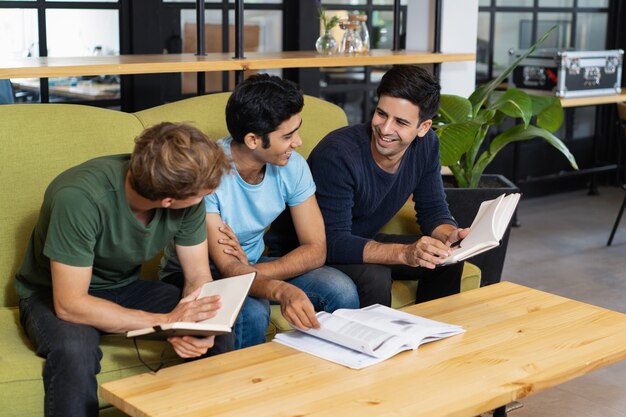 Tres compañeros de clase relajados que estudian y chatean