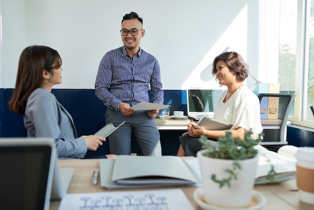 Tres compañeros de trabajo discutiendo el proyecto en la cita en la oficina