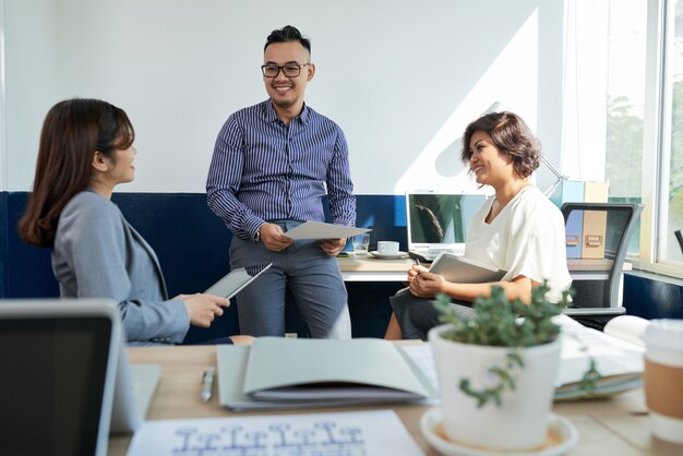 Tres compañeros de trabajo discutiendo el proyecto en la cita en la oficina