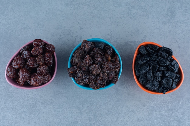 Foto gratuita tres cuencos de frutos secos, sobre la mesa de mármol.