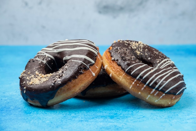 Tres donas de chocolate en el cuadro azul.