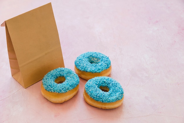 Tres donuts azules con parcela en fondo rosa