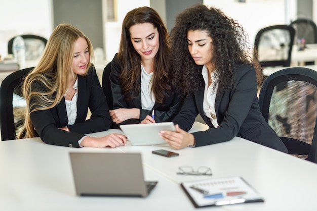 Foto gratuita tres empresarias trabajando juntos en una oficina moderna