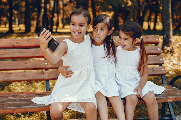 Tres hermanitas sentadas en un parque de verano