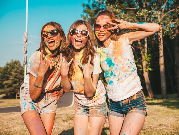 Tres hermosas chicas sonrientes posando en la fiesta de Holi