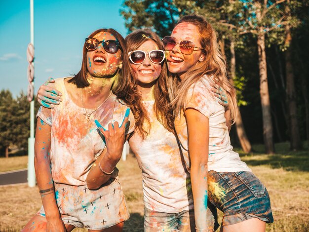 Tres hermosas chicas sonrientes posando en la fiesta de Holi