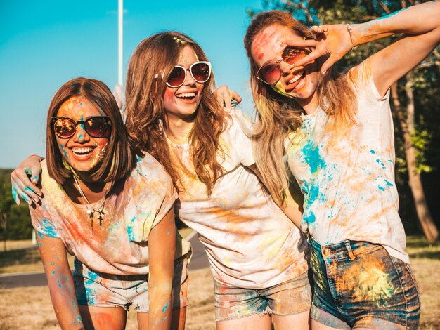 Tres hermosas chicas sonrientes posando en la fiesta de Holi