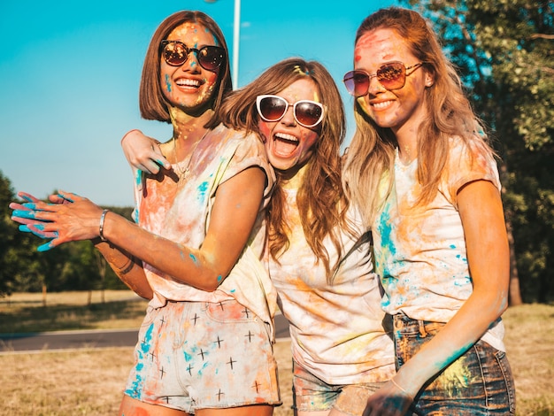 Foto gratuita tres hermosas chicas sonrientes posando en la fiesta de holi