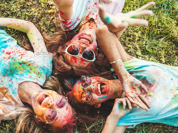 Foto gratuita tres hermosas chicas sonrientes posando en la fiesta de holi