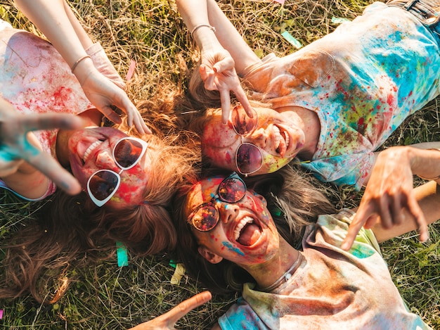 Foto gratuita tres hermosas chicas sonrientes posando en la fiesta de holi