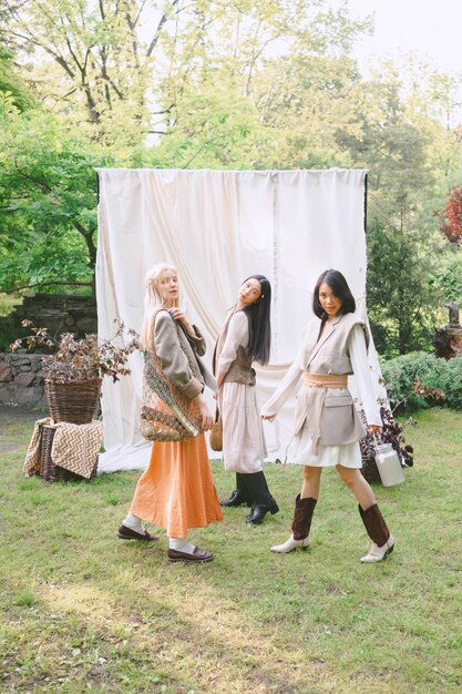 Tres hermosas mujeres de pie en el jardín.