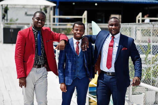 Foto gratuita tres hombres afroamericanos felices y exitosos en traje hombres de negocios negros ricos