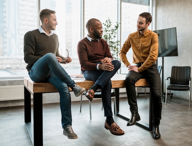 Tres hombres conversando en la oficina durante una reunión