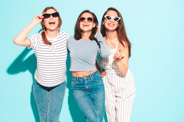 Tres jóvenes hermosas mujeres hipster sonrientes en ropa de moda del mismo verano