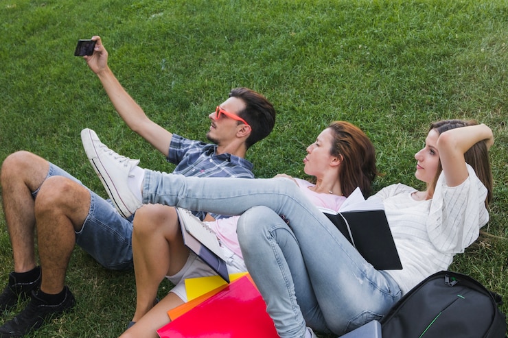 Foto gratuito tres jóvenes que toman selfie mientras que estudia