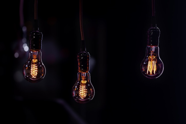 Foto gratuito tres lámparas luminosas cuelgan en la oscuridad del boke. concepto de decoración y ambiente.