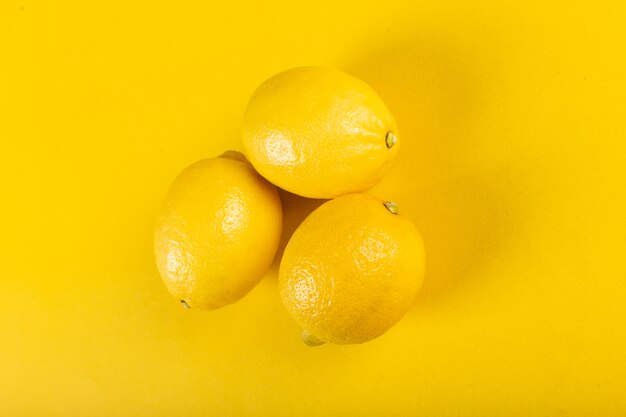 Tres limones frescos y brillantes en amarillo