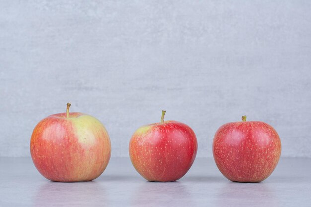 Tres manzanas frescas enteras sobre fondo blanco. Foto de alta calidad