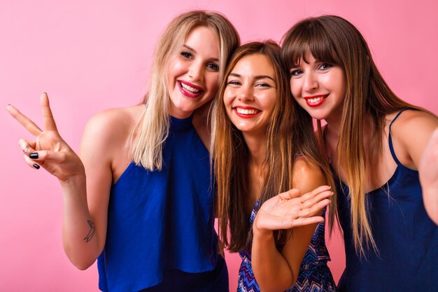 Tres mujeres bastante divertidas abrazos y enviando besos al aire, abrazos y disfrutan del tiempo juntos