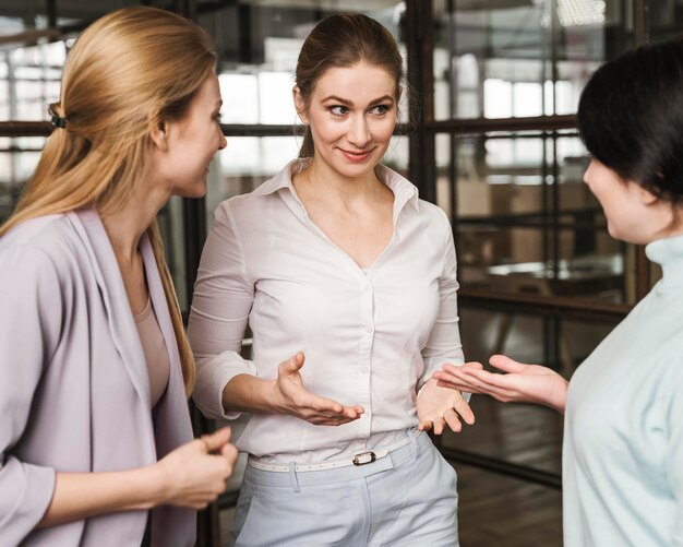 Tres mujeres empresarias discutiendo en interiores