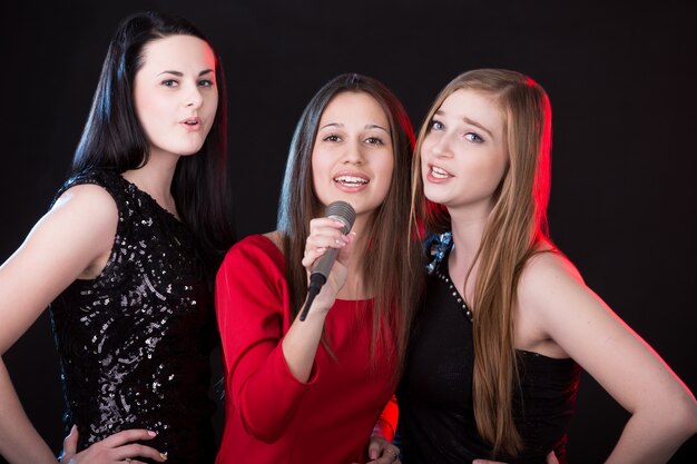 Tres mujeres jóvenes atractivas que cantan