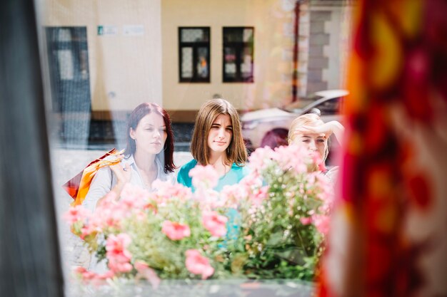 Tres mujeres mirando por la ventana de la tienda