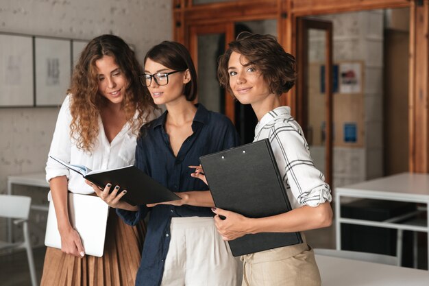 Tres mujeres de negocios en la oficina de trabajo conjunto