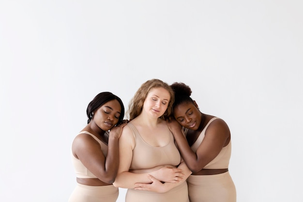 Tres mujeres posando juntas en modeladores corporales