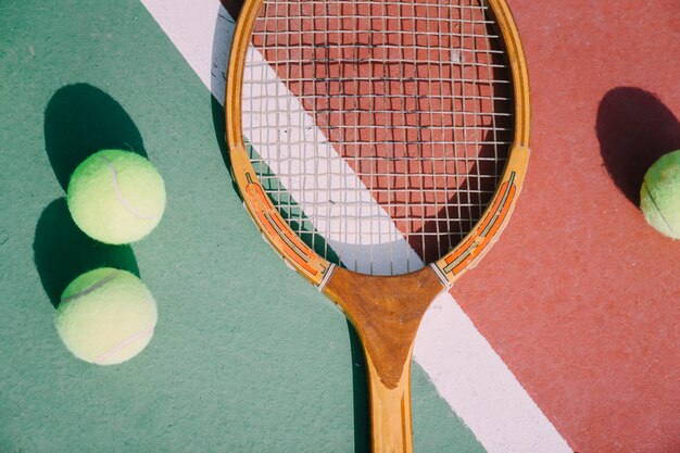 Tres pelotas de tenis y raqueta