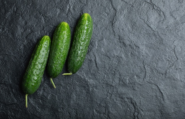 Tres pepino fresco sobre fondo negro. Vegetales orgánicos frescos.