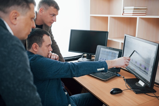 Tres personas. Los examinadores de polígrafo trabajan en la oficina con el equipo de su detector de mentiras