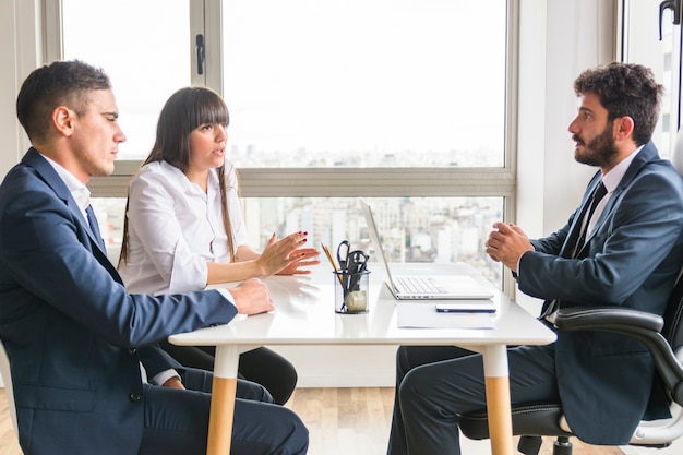 Tres profesionales de negocios discutiendo en la oficina.