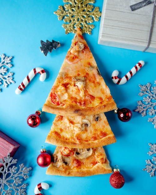 Foto gratuita tres rebanadas de pizza decoradas en forma de árbol de navidad