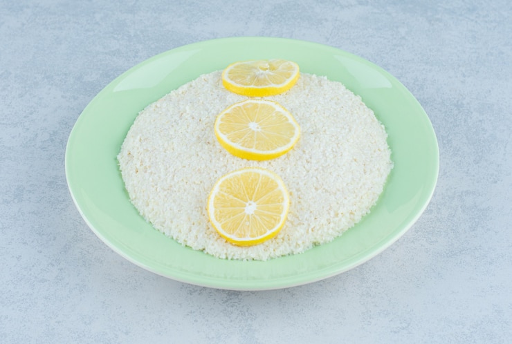 Foto gratuito tres rodajas de limón alineadas sobre arroz sobre mármol.